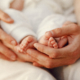 Photo de mains adultes soutenant les pieds nus d'un bébé